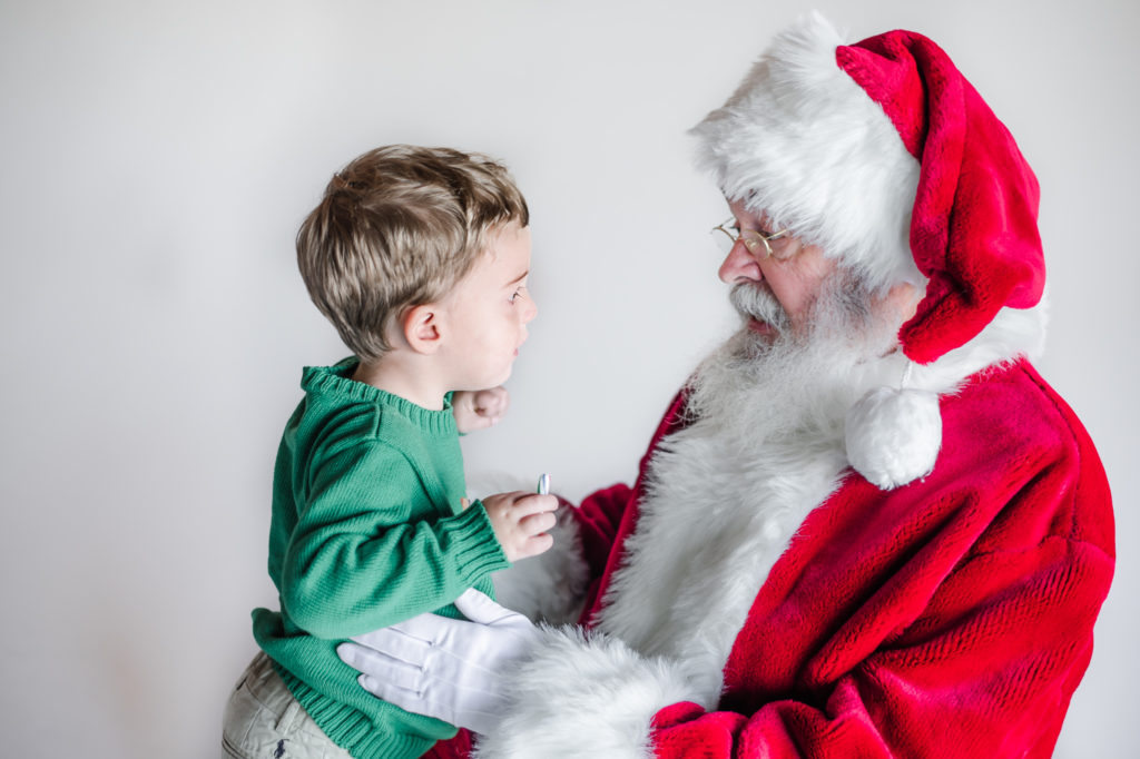Santa Claus talking to young boy during 2020 Santa Mini photo session