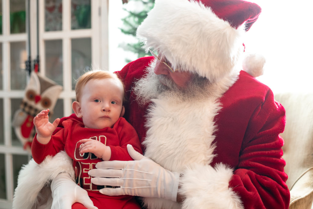 Baby sitting on Santa's lap during a “Home for the Holidays” Santa Session