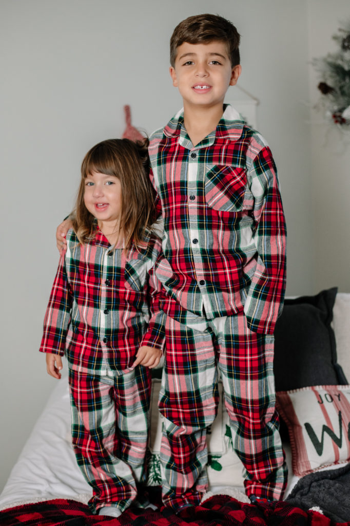 Siblings in matching Christmas pajamas