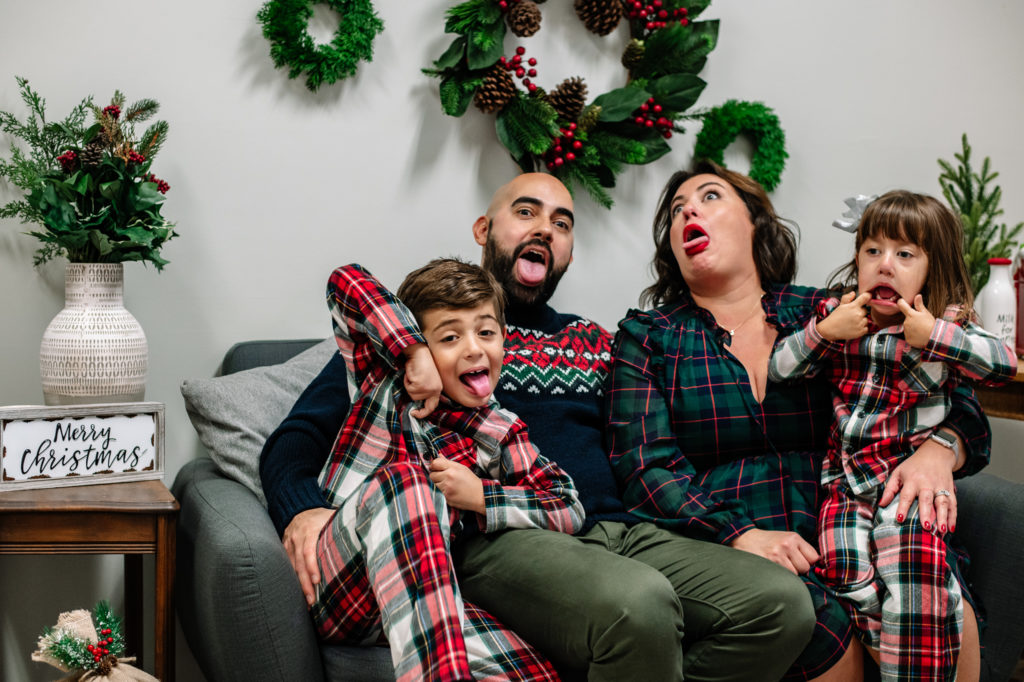 Diaz family sitting on couch and acting silly during a family Christmas photo session in Chattanooga