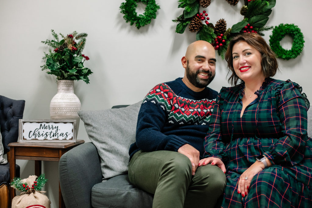 Mr. and Mrs. Diaz sitting on a couch having their photo taken during a family Christmas photo session in Chattanooga 