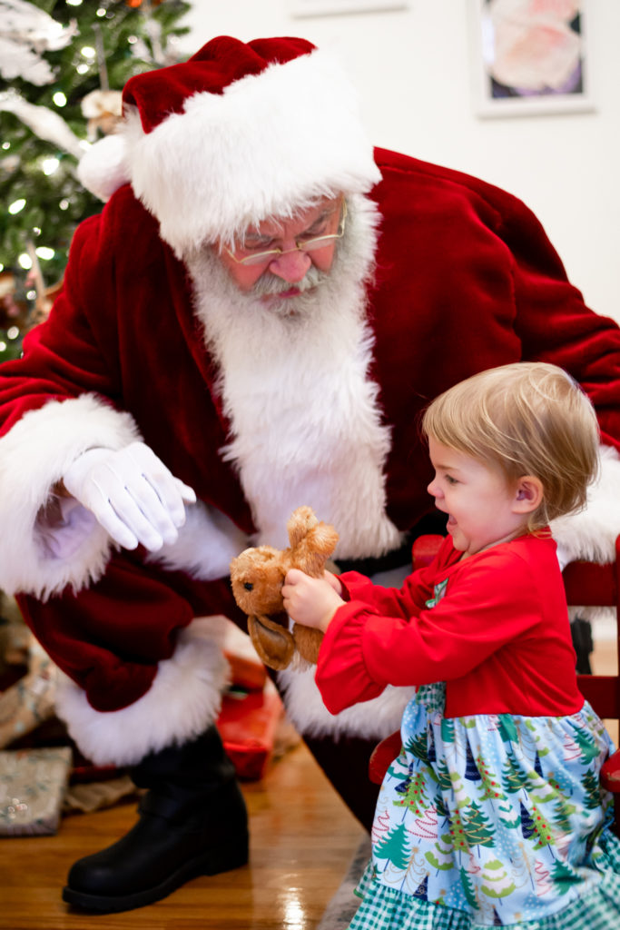 Santa Claus with toddler girl during "Home for the Holidays" Santa session