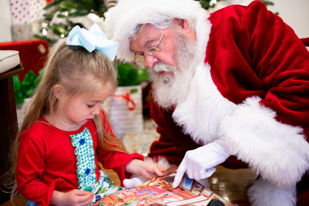 Santa and young girl reading a book during "Home for the Holidays" Santa session