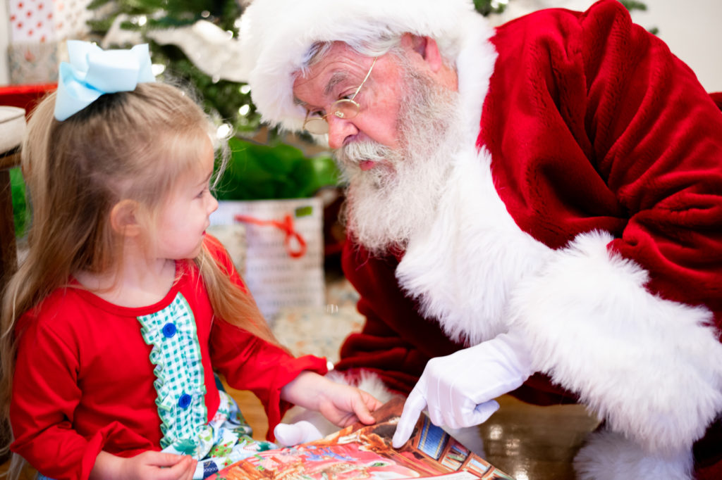 Santa Claus and young girl reading a book 