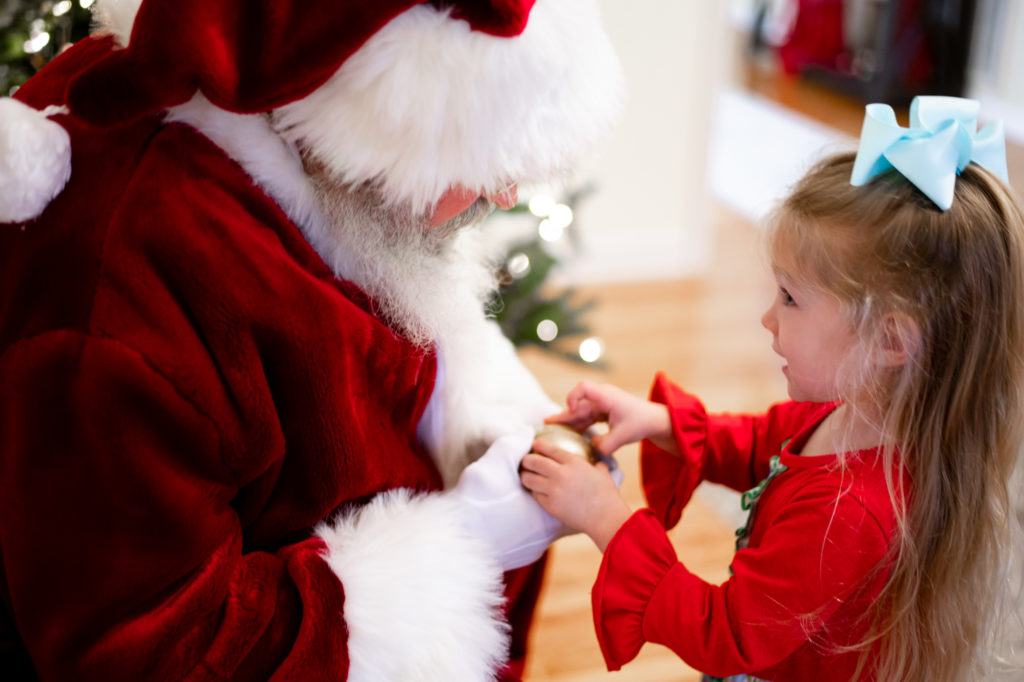 Young girl interacting with Santa Claus during "Home for the Holidays" Santa session
